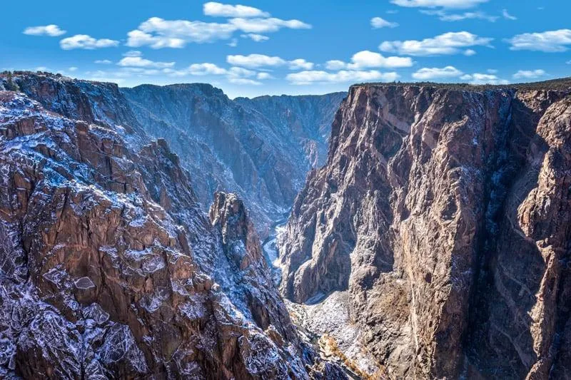 Snow-covered Black Canyon of the Gunnison in winter showing the dramatic contrast between white snow and dark canyon walls
